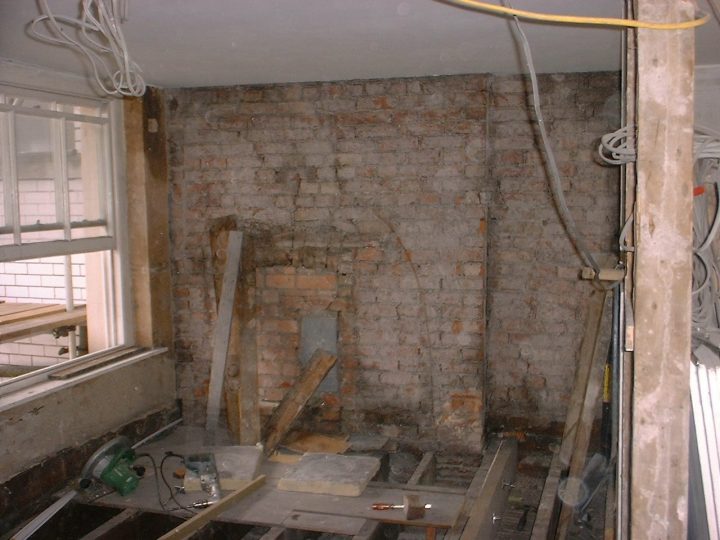 Bare brickwork and an old fireplace opening, exposed during the works