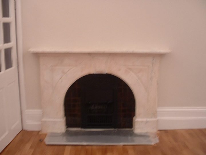 A marble fireplace kept in the first-floor room