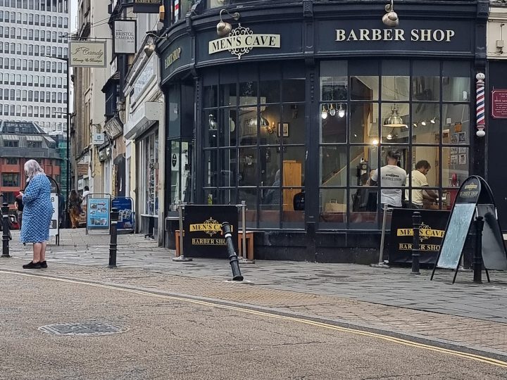 Bart- und Haarschneider- (Frisör; Friseur)-Shop Men's Cave Barber Shop in 49 High Street Ecke Corn Street und Broad Street in