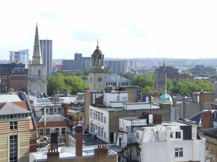 Roofscape of central Bristol showing the tower and spire of the parish church of Christ with St Ewen (left), the