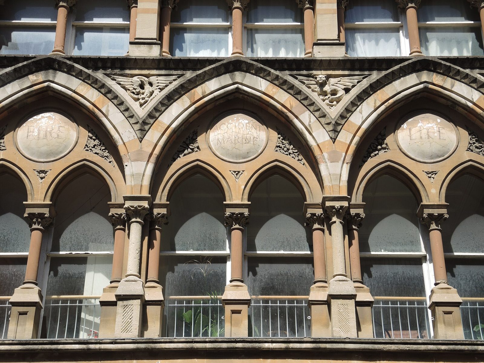 The first-floor arcade, with the words Fire, Accident, Marine, Life in its roundels